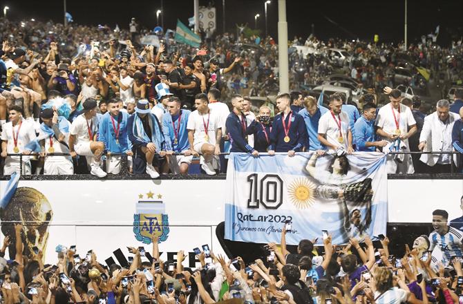 Argentina football team players can be seen on an open bus. Millions of people were on both sides of the road to get a glimpse of the world champion players.